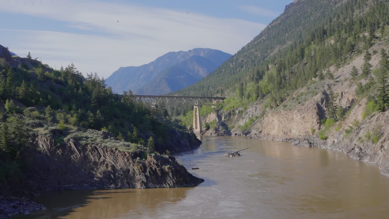 Metalbro krydser Fraser River i et bjergrigt dallandskab i Lillooet i British Columbia, Canada.