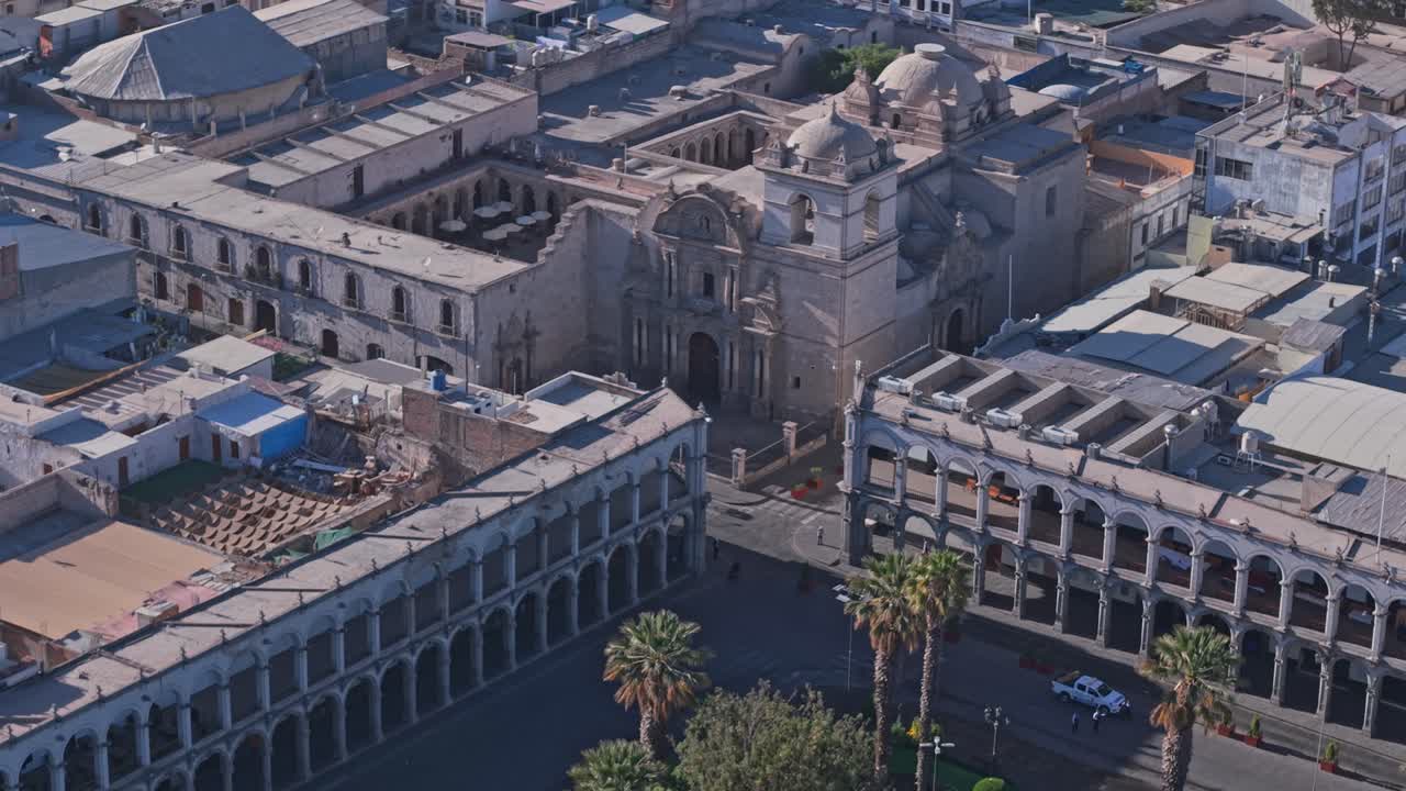 Iglesia Barroca Andina de la Compañía de Jesús en la Plaza de Armas de Arequipa mientras un dron retrocede revelando el histórico complejo colonial.