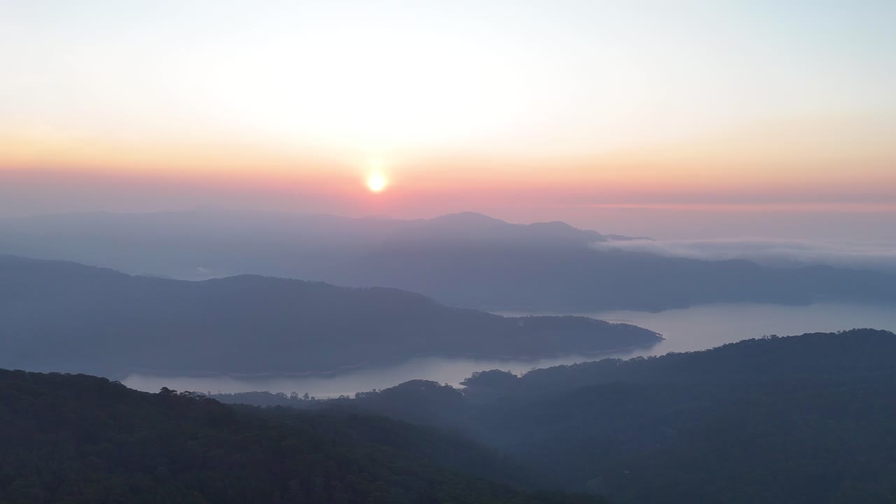 unrise over lake between valley and clouds