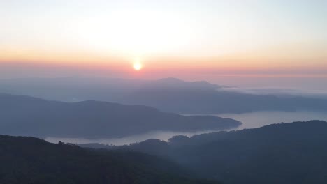 unrise over lake between valley and clouds