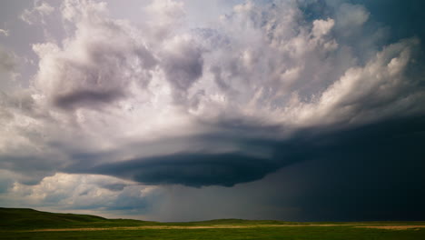 dramatic storm clouds with rain shaft over green fields