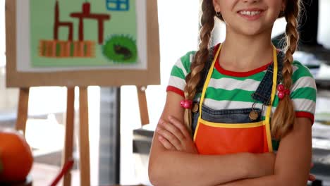 retrato de una escolar linda de pie con los brazos cruzados en la mesa 4k