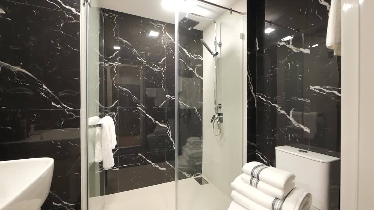 Elegant badeværelse med marmormønstret vægdekoration.