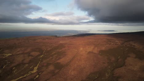 vista lejana de la ciudad de dublín desde las montañas de wicklow en irlanda en un clima nublado - drone ascendente
