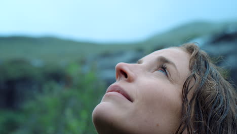 woman looking up at the mountains on a rainy day