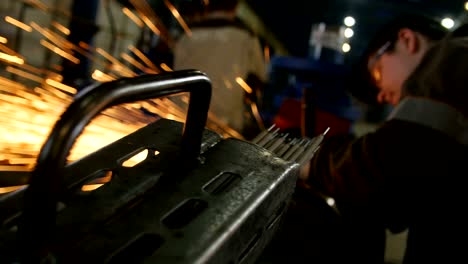 trabajador calificado en soldaduras de máscaras con ducha de chispas