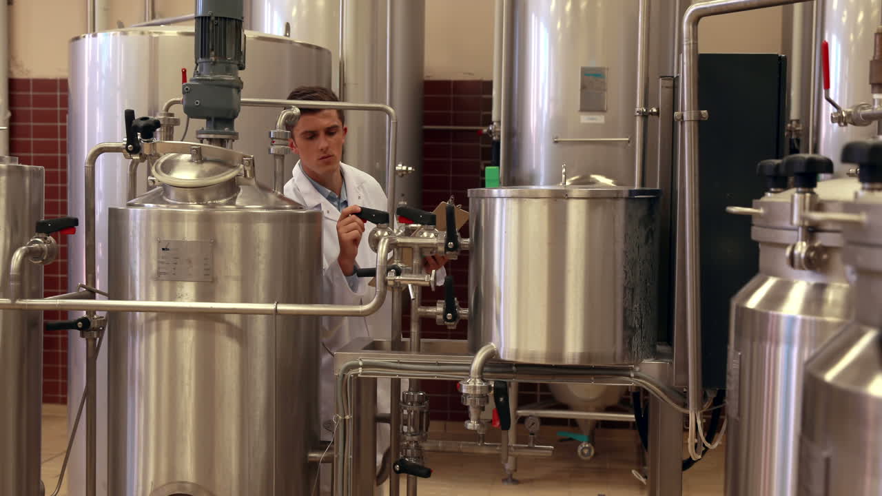 Brewery worker checking the vats