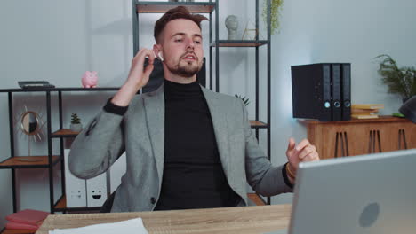 hombre de negocios trabajando en una computadora portátil en la oficina con auriculares escuchando su música disco energética favorita