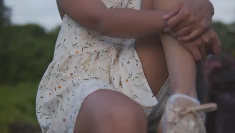 extremo close-up jib tiro de una hermosa joven india de la cabeza a los pies, sentado en una pared al aire libre