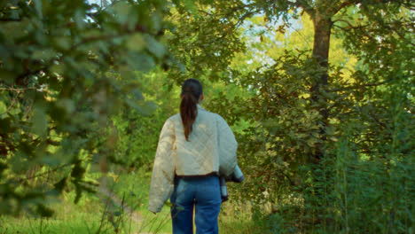 una mujer caminando por un bosque.