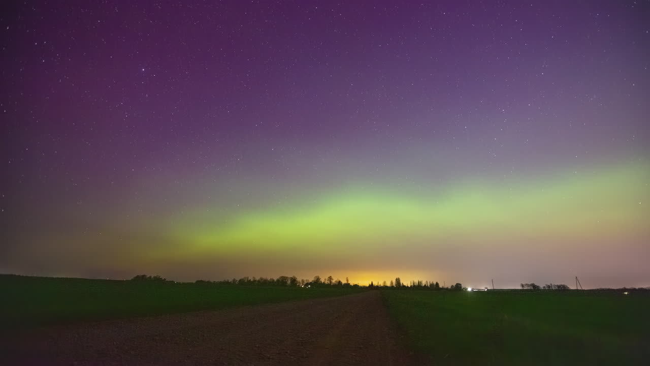 aurora boreal brillando sobre el paisaje rural, vista en lapso de tiempo