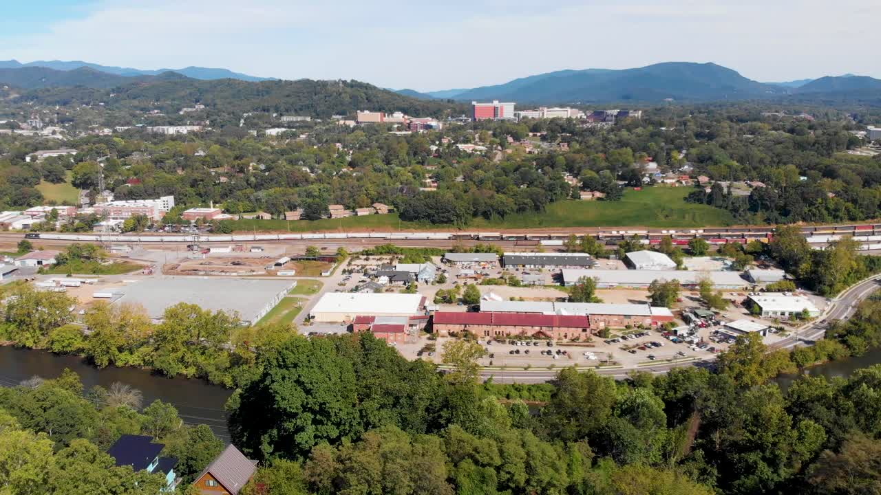 video aéreo de drones de 4k del patio de trenes del sur de norfolk y el distrito de artes fluviales a lo largo del amplio río francés en asheville, nc