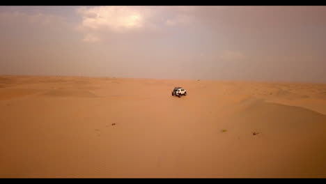 Aerial-view-of-two-trucks-on-an-extreme-dune-bashing-competition-in-the-desert