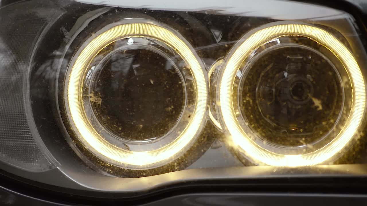 겨울 저녁에 전면 주차등이 켜진 자동차 주변, 카메라가 오른쪽에서 왼쪽으로 패닝