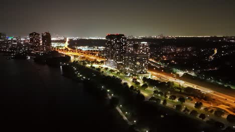 night aerial of parklawn with glowing city lights, waterfront, and illuminated roads in toronto