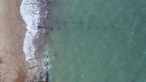 Imágenes-Aéreas-De-Arriba-Hacia-Abajo-De-Las-Defensas-Contra-El-Mar-En-El-Mar-Hacia-La-Playa-Con-Olas-Rompiendo-En-La-Playa