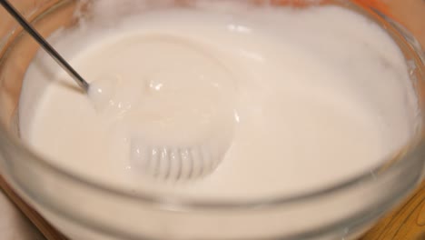 mixing whipped cream in a glass bowl