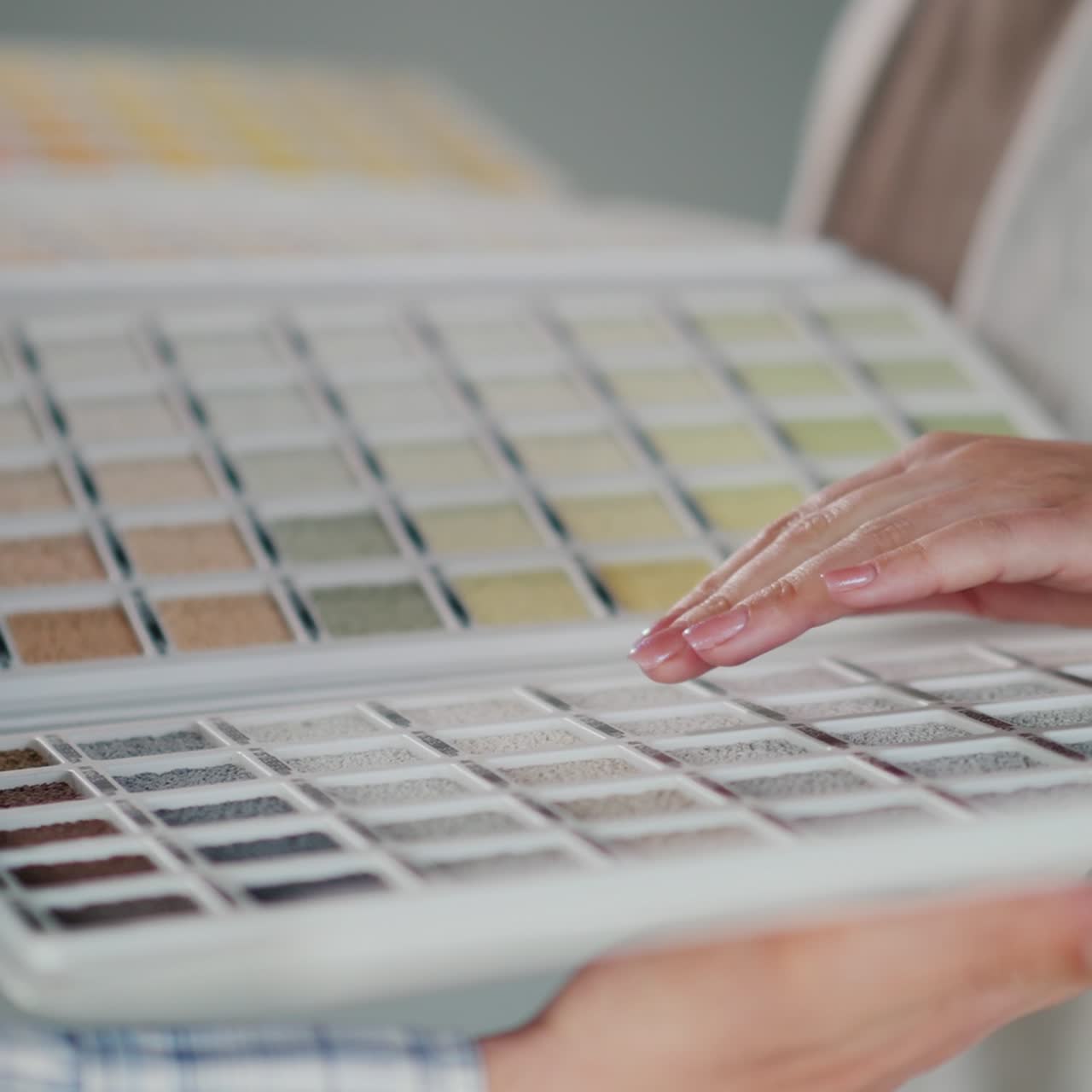 el comprador elige la pintura en el catálogo con muestras