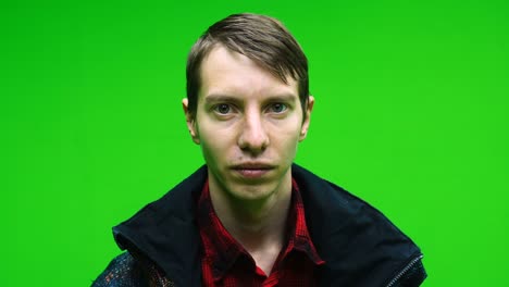 young upset sad man looking at camera on green screen background. unhappy alone. chroma key