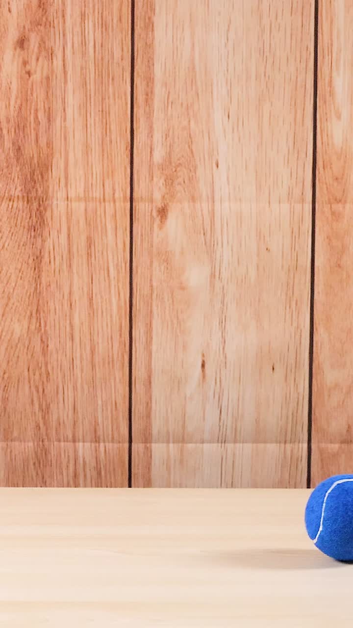 una pelota de tenis azul se mueve a través de un estante