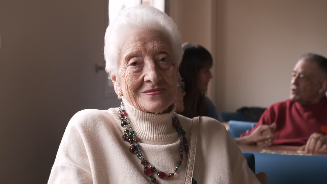 Senior woman waving hand in retirement home