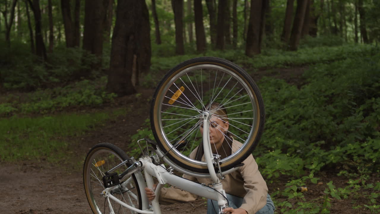 A woman with a bicycle in the forest