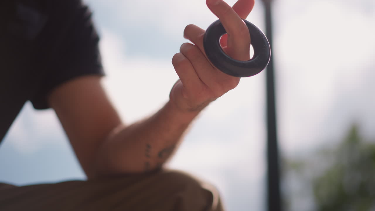 Urban Artist Demonstrates Ring Mastery, Public Display Of Agility Through Ring Magic In City Setting, Performer In Urban Area Exhibits Remarkable Skill Executing Ring Tricks Publicly