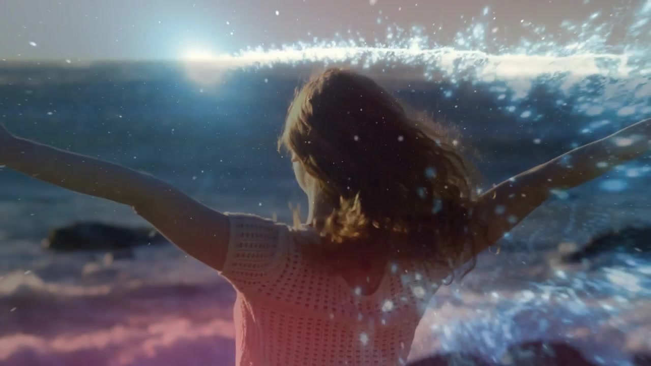 Video vertical: Mujer levantando los brazos en la orilla, con una superposición de agua brillante envolviendo su torso para marketing.