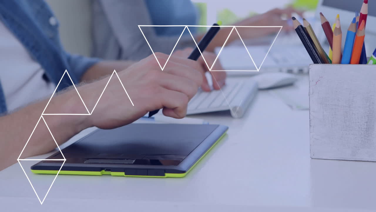 Hands working on tablet and keyboard with geometric shapes overlay animation
