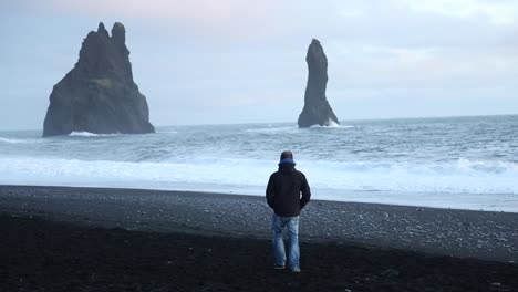 man walking on a dark beach