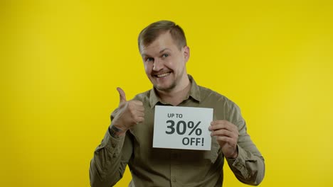 smiling man showing up to 30 percent off inscriptions signs, rejoicing good discounts, low prices