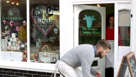 pareja escribiendo en el tablón de anuncios fuera del café filmado en r3d