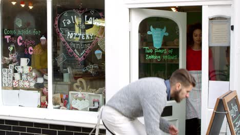 couple writing on noticeboard outside cafe shot on r3d