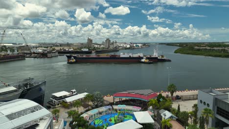 tugboats positioning a tanker into port drone view