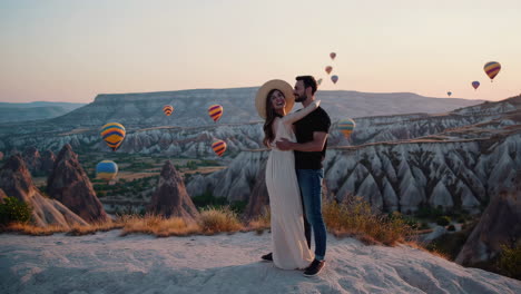 romantic couple embracing amidst hot air balloons in cappadocia