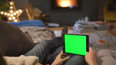 couple relaxing on couch with tablet and green screen