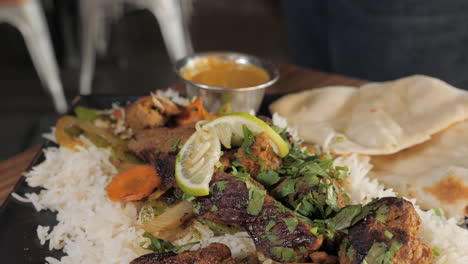 fork takes a yummy bite from plate of beef kabob dish, slow motion close up slider pull 4k