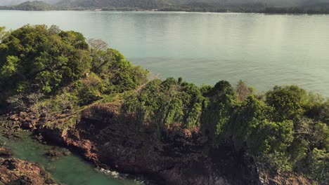 aerial backwards dolly shot of small rocky tropical island off the coast of koh chang, thailand