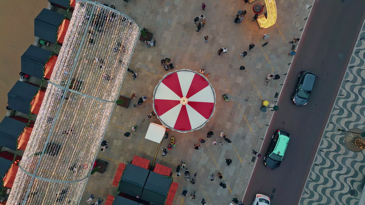 Aerial festive square shining with twinkling lights. Carousel spinning festival