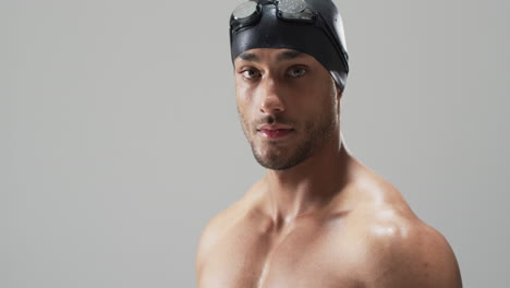 young biracial athlete swimmer wearing swimming goggles, with copy space