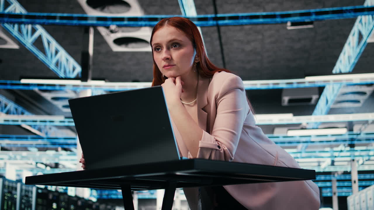 Focused Woman Working on Laptop in Modern Data Center