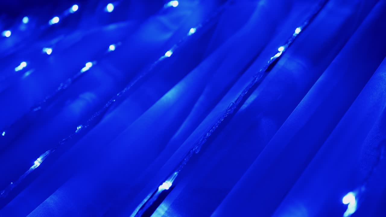 Christmas Garland of Many Blinking, Flickering Blue LED Lights on Curtain. 4K