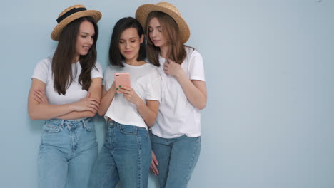 three young women looking at a smartphone