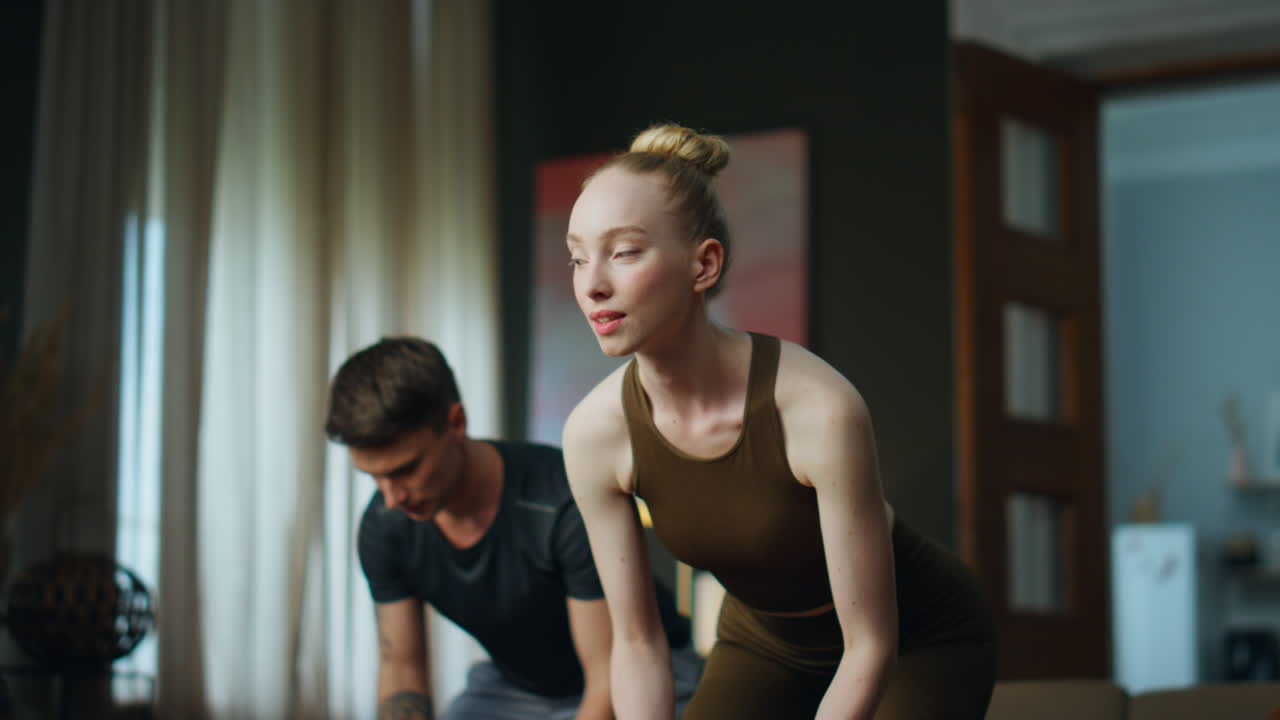 семья занимается физкультурой с помощью гантелей дома. пара тренирует силу рук.