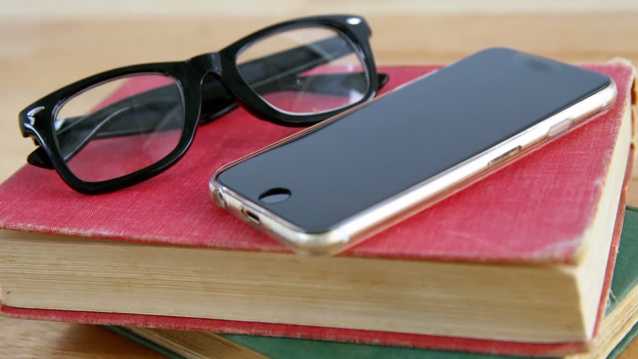 teléfono móvil con gafas y libro