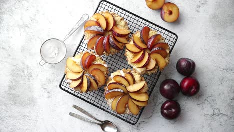 homemade crumble tarts with fresh plum slices placed on iron baking grill