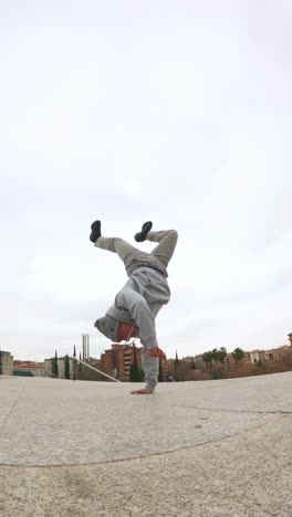 breakdancer performing handstand freeze in urban environment