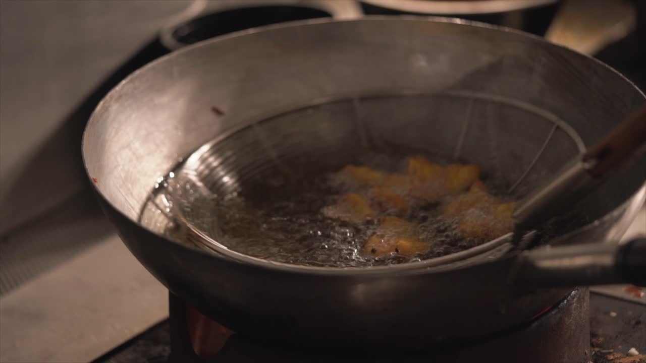 chef che cucina gamberi fritti nella grande padella vista ravvicinata