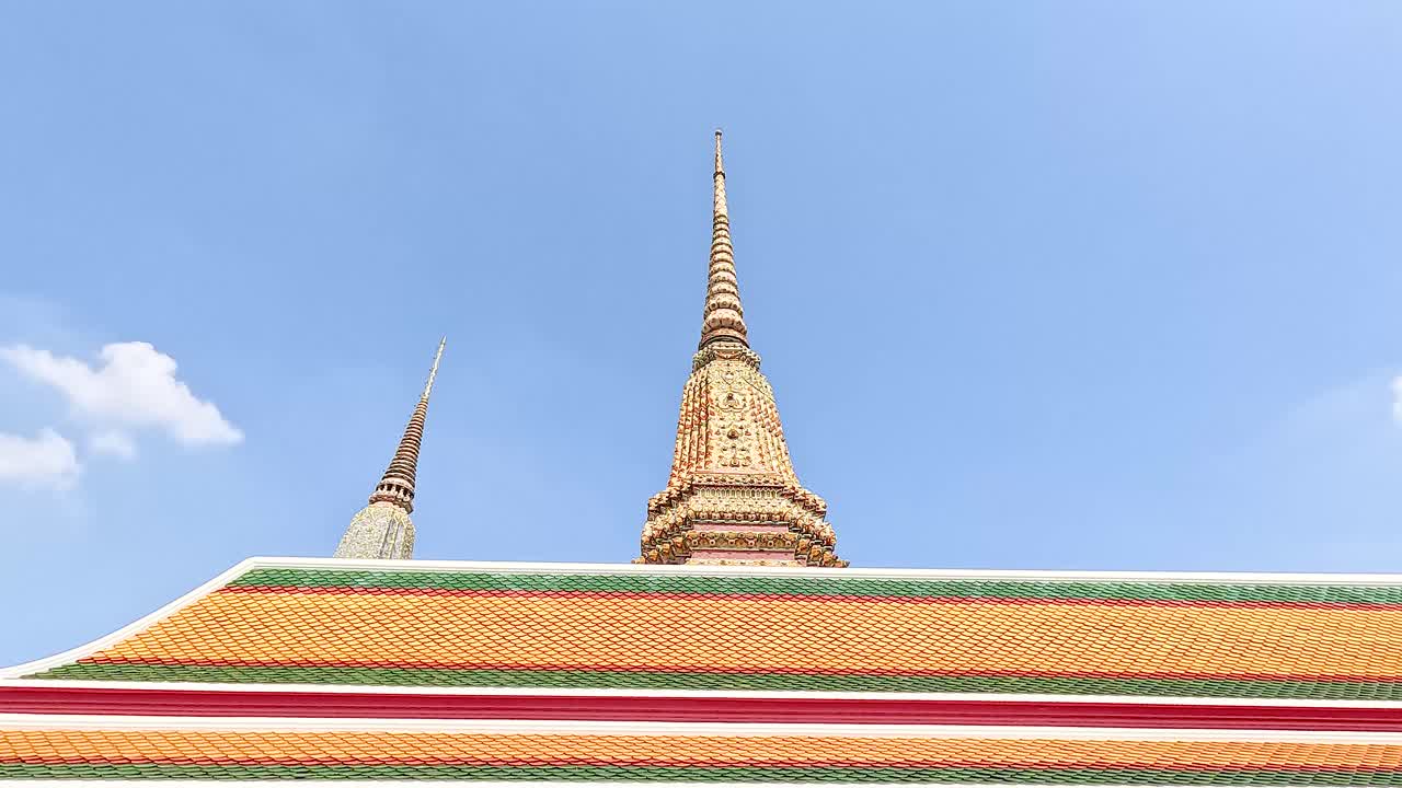 방의 밝은 파란 하늘을 배경으로 wat phou의 파고다의 조용한 풍경, 전통적인 태국 건축과 활기찬 색을 보여줍니다.