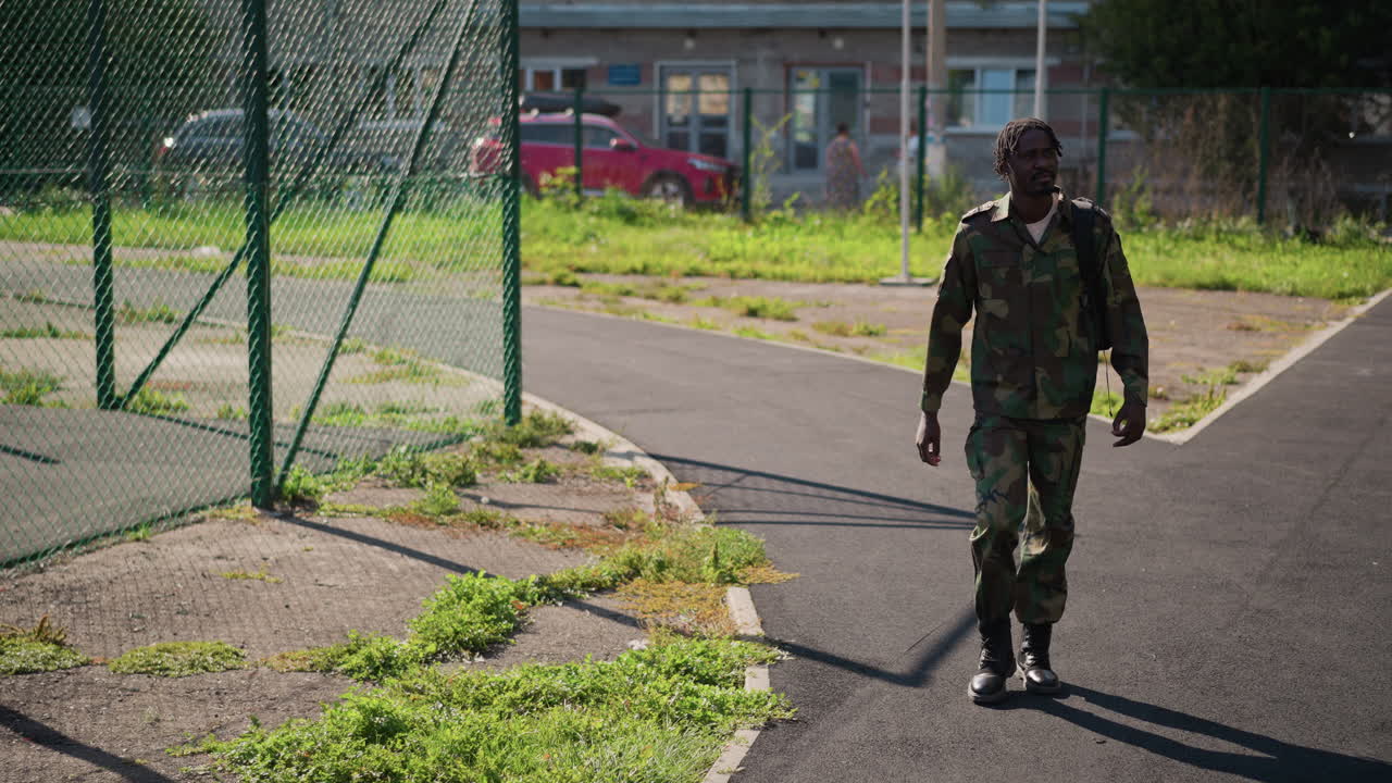 Invisible Soldier Advances Through Peaceful Neighborhood With Cheerful Backdrop, Concealed Combatant Navigates Bright Sunlit Pathway Amidst Residential Surroundings With Colorful Vehicle Background